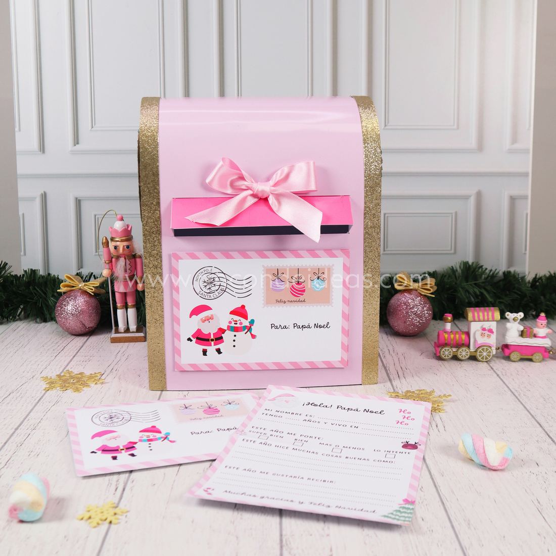 Buzón de Papá Noel rosa con techo curvo dorado, moño de raso y carta para Papá Noel con sobre al frente · Masterclass de Navidad 2026