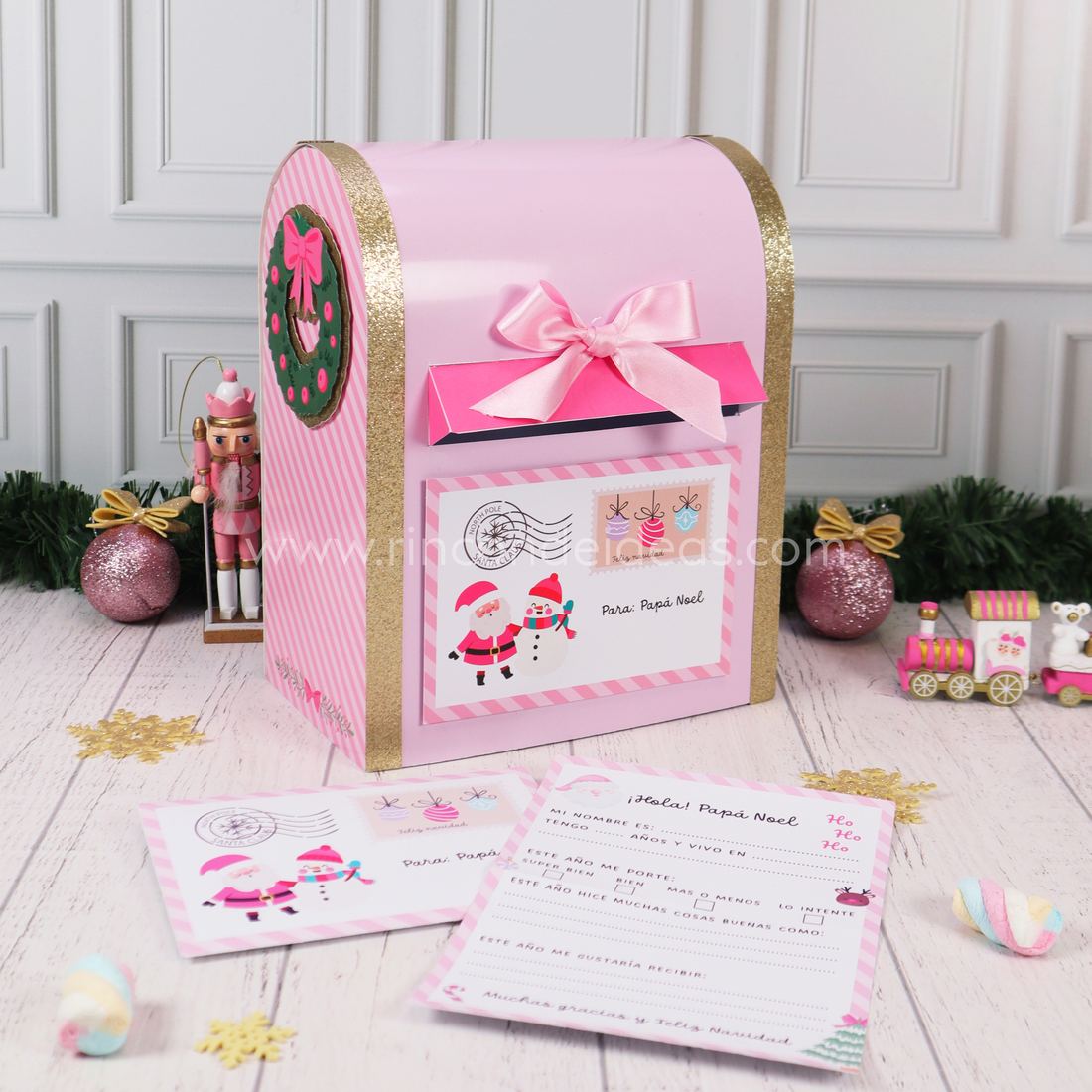 Buzón de Papá Noel rosa en tres cuartos, con corona navideña en el lateral rayado y carta al frente · Masterclass de Navidad 2026