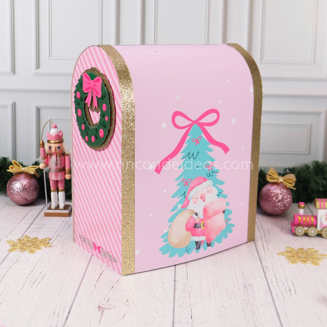 Dorso del buzón de Papá Noel rosa con Papá Noel ilustrado, arbolito verde agua y corona en el lateral · Masterclass de Navidad 2026