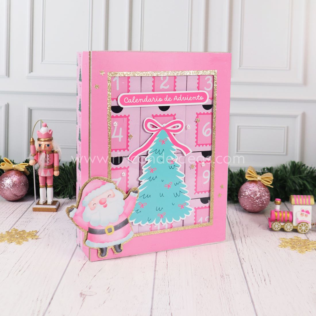 Calendario de Adviento rosa con ventana, árbol verde agua y Papá Noel con glitter dorado, en tres cuartos · Masterclass de Navidad 2026