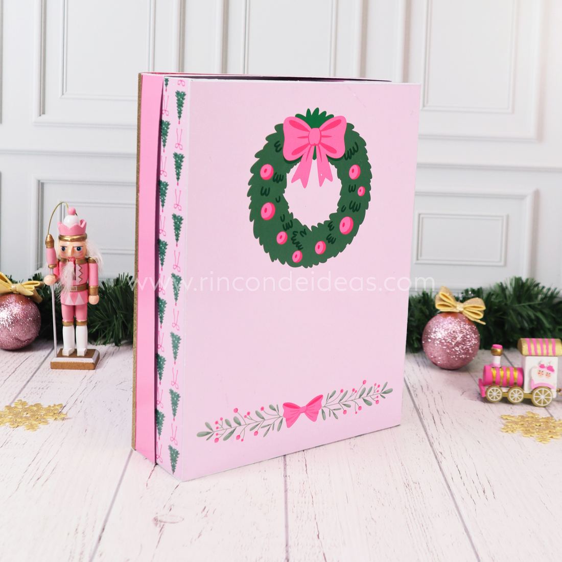 Dorso del calendario de Adviento rosa con corona verde y moño fucsia, y lateral con arbolitos · Masterclass de Navidad 2026