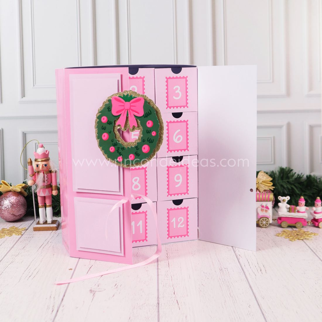 Calendario de Adviento con puertas, una abierta con la corona y cajitas numeradas con estampilla · Masterclass de Navidad 2026