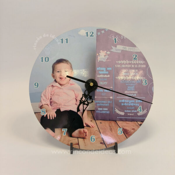 Reloj redondo sublimado con foto infantil sobre piso de madera y números del reloj · Curso de Sublimación