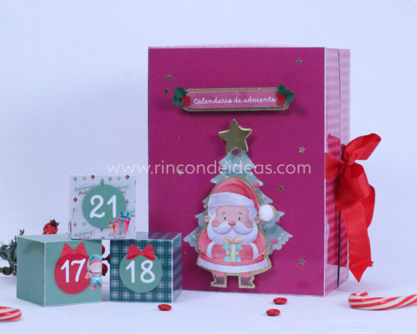Calendario cerrado con moño rojo junto a cajitas numeradas · Masterclass de calendarios de adviento, esferas y topper