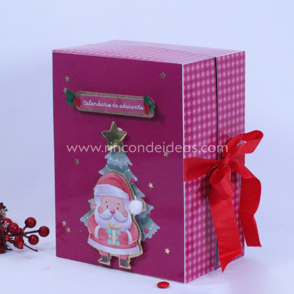 Calendario de adviento fucsia cerrado con Papá Noel y moño · Masterclass de calendarios de adviento, esferas y topper